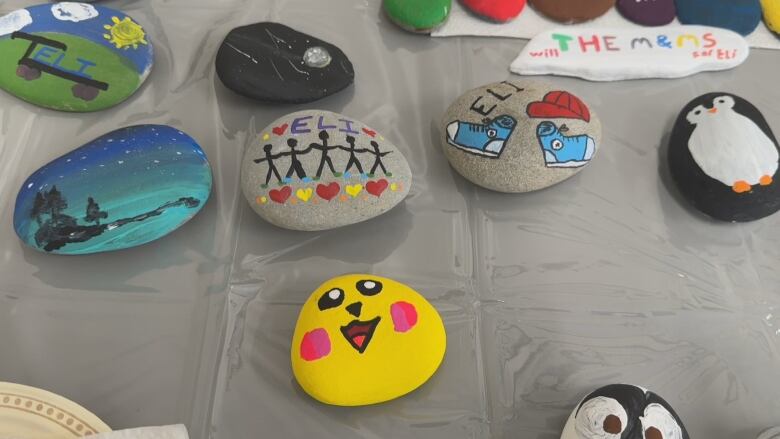 A table holds several painted rocks, including a Pikachu and penguin.