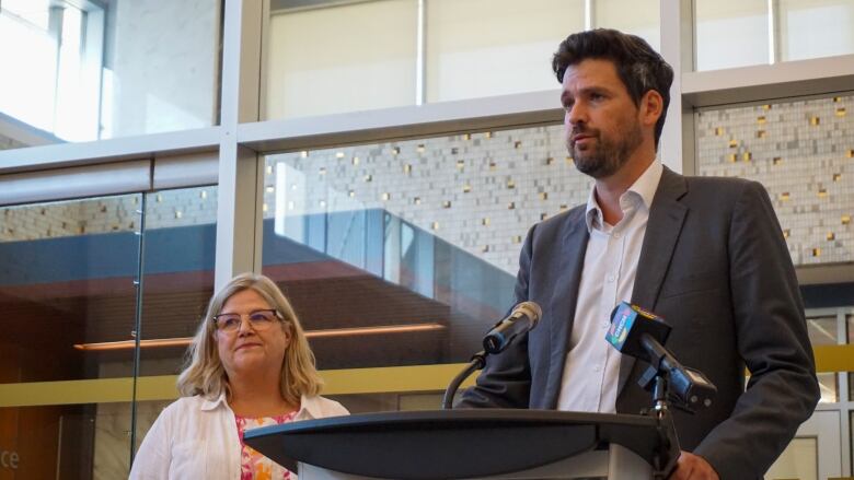 Two people speaking at a podium.