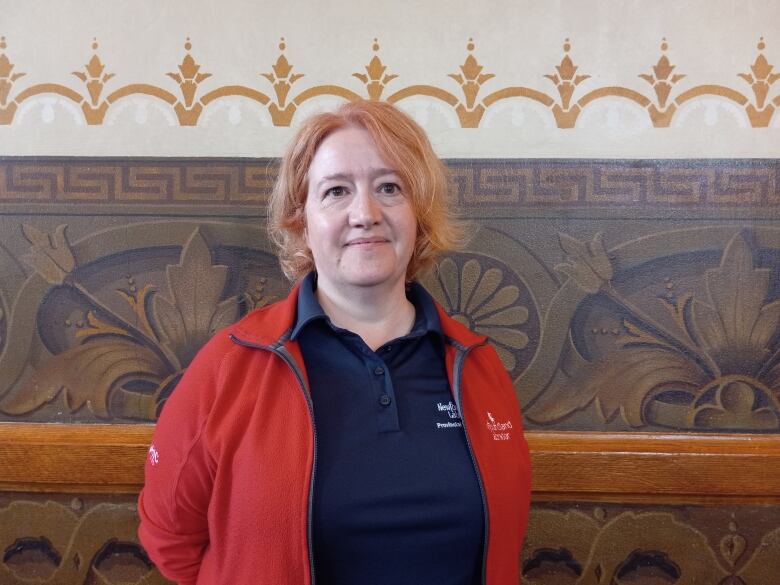 Woman with short red-ish hair in a red jacket