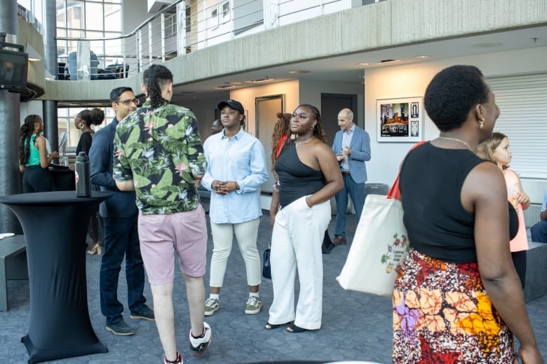 A crowd of event attendees engage in general conversation.