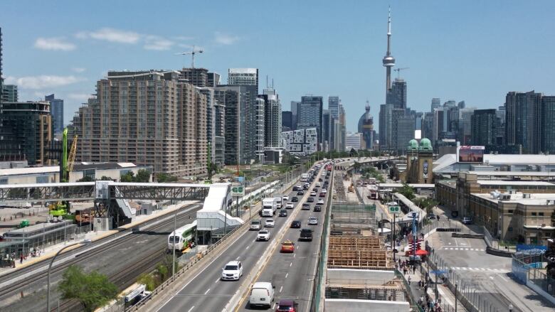 Aerial (drone) images of the Gardiner undergoing demolition and re-construction, east of Dufferin. Cars drive next to construction and condos on a sunny day