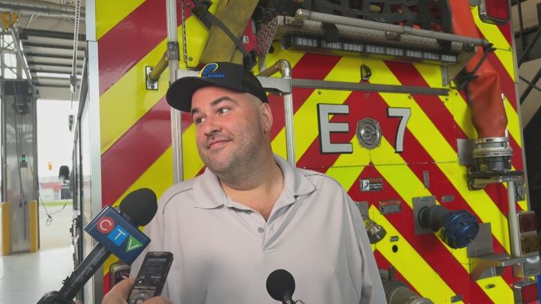 A man stands in front of a fire truck