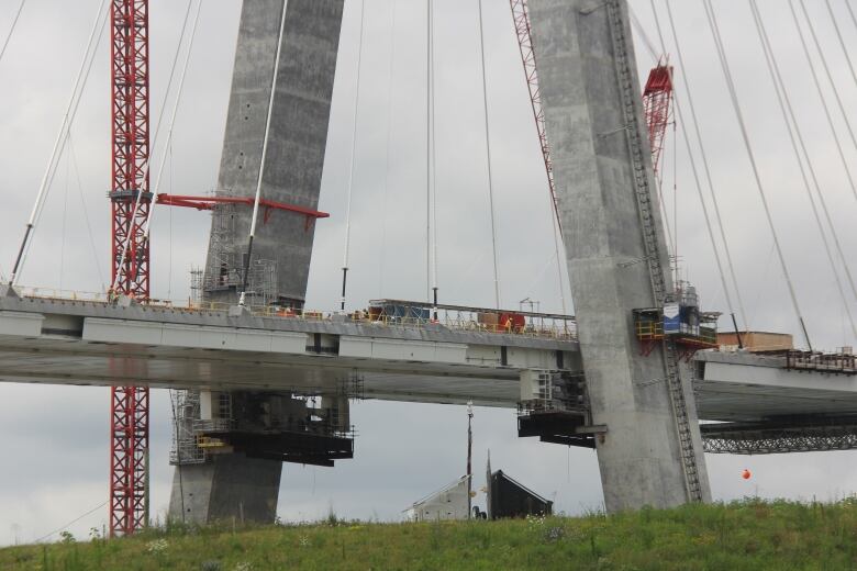 A concrete bridge with cranes and construction equipment on it.