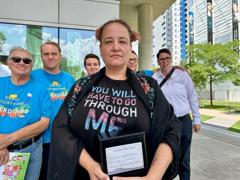 A woman standing with supporters on courthouse steps.