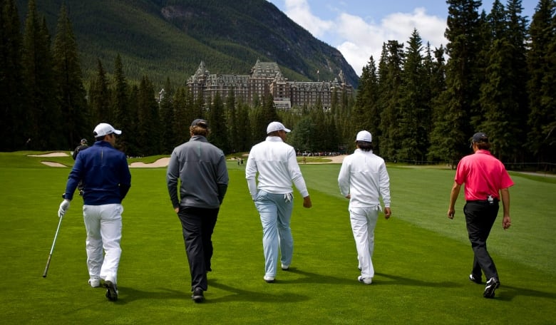 Golfers walk along a fairway towards the Banff Springs Hotel in Banff, Alta., Tuesday, July 26, 2011.