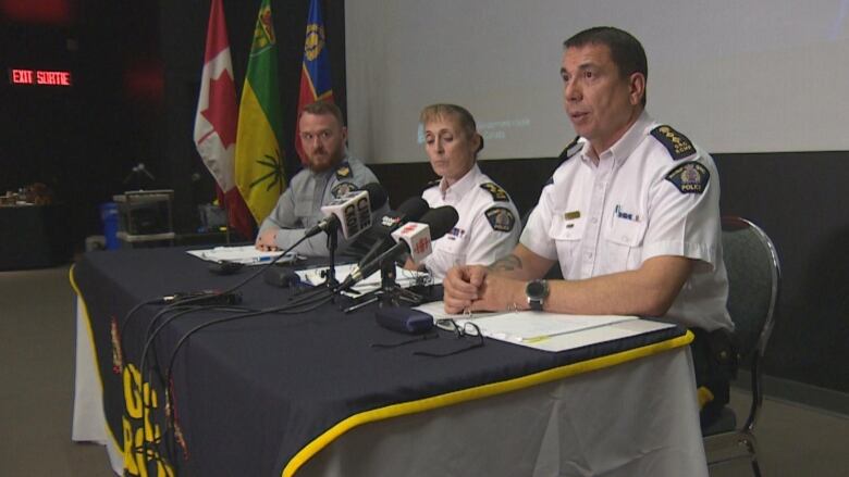 Three people in uniforms sitting. 