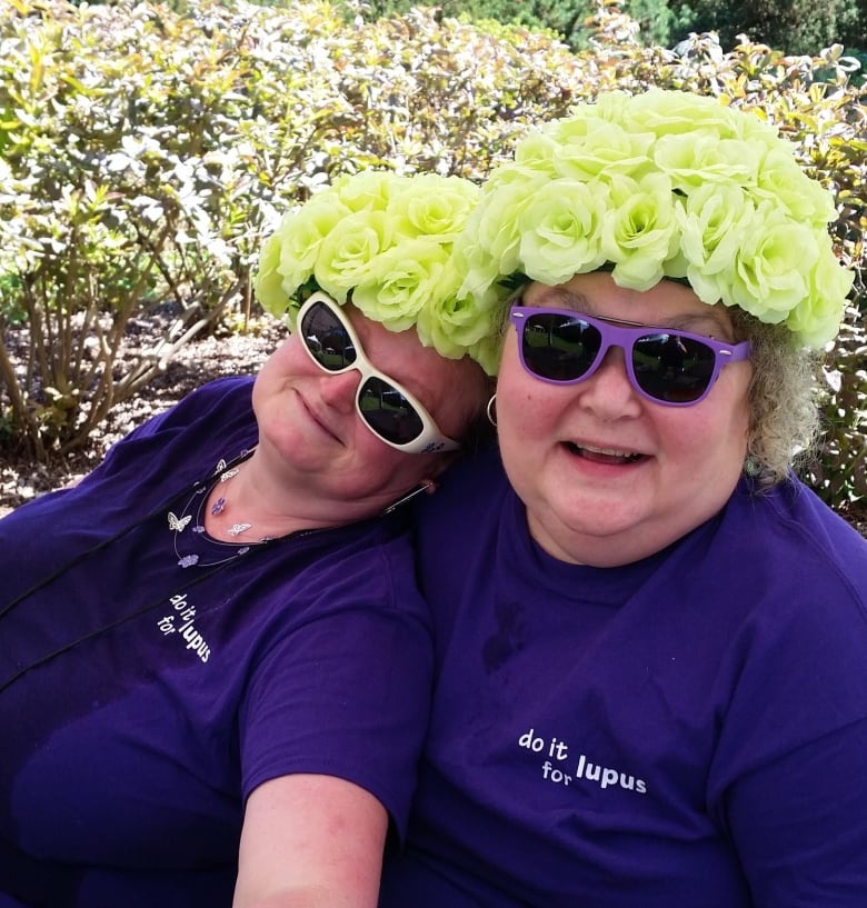 Two ladies wear purple shirts with 