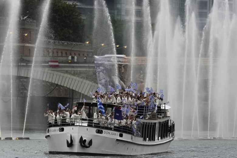 A boat with Olympians from Greece floats down the Seine River.