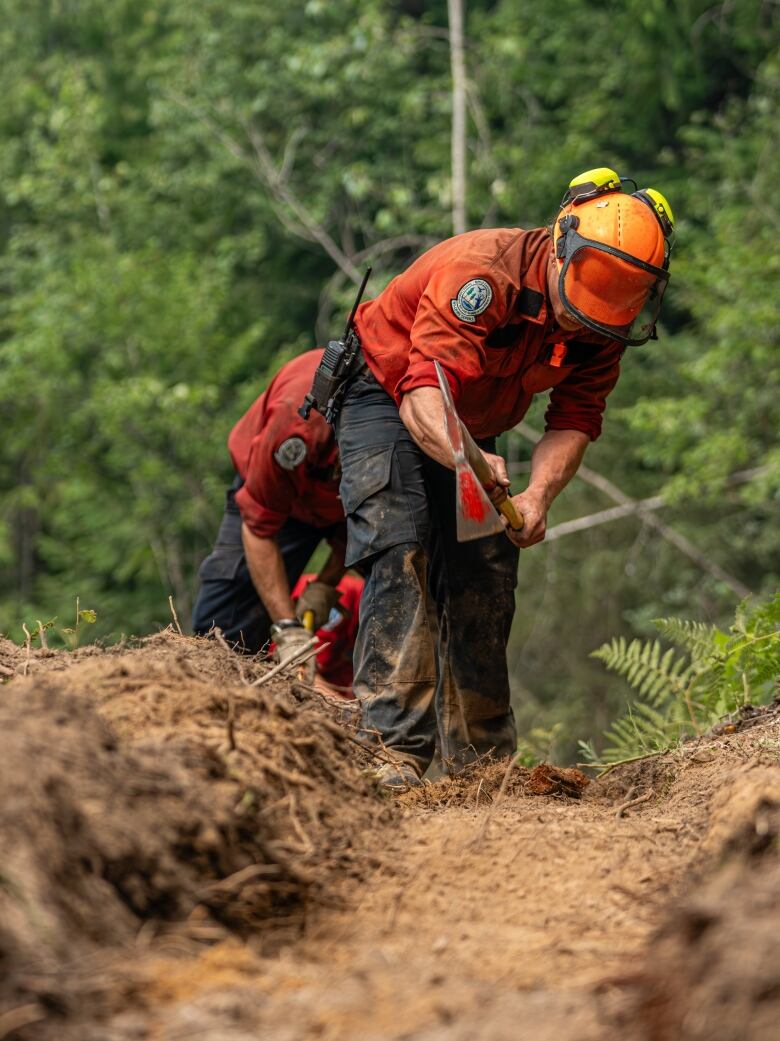 Fire fighter crews establishing a control line using a pulaski.