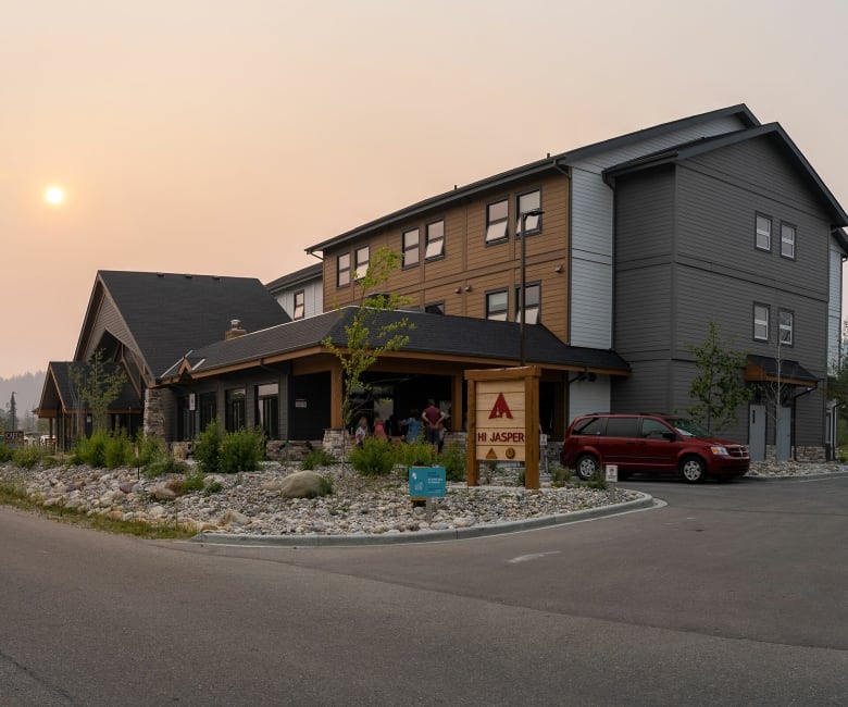 A hotel-style lodge in front of a hazy sunset.