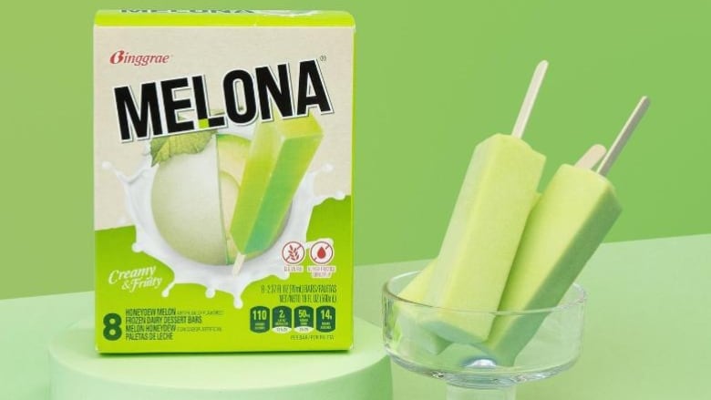 A green box of popsicles is pictured next to a cup with unwrapped green popsicles.