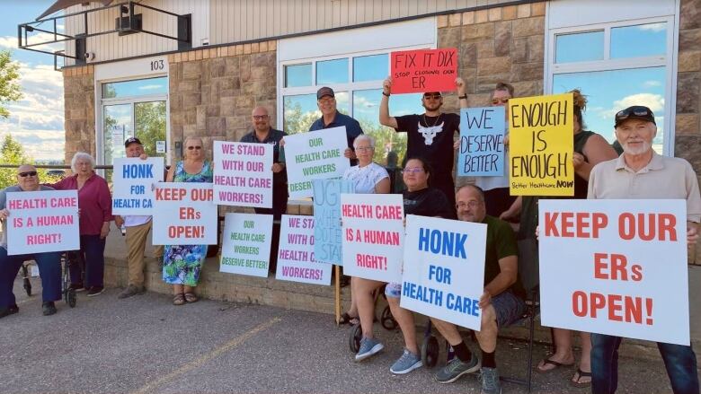 People hold up signs supporting health-care workers at a rally.