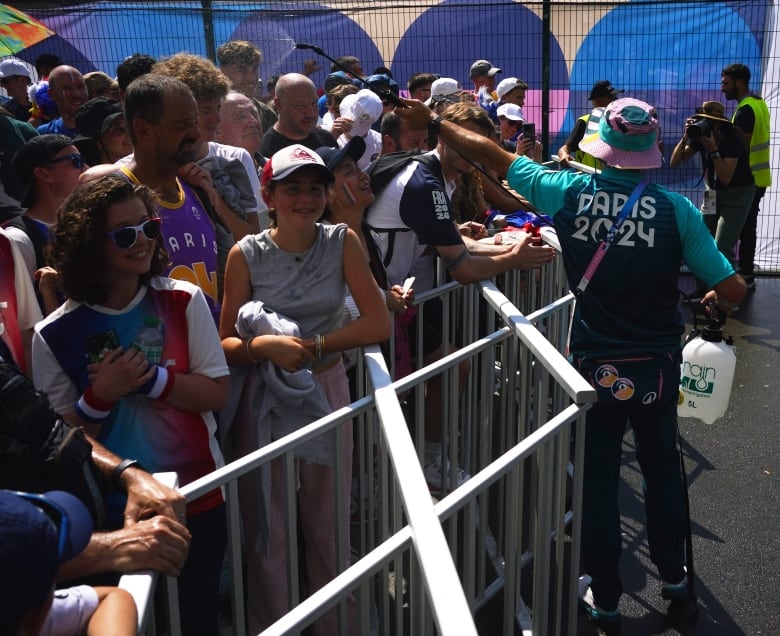 A person mists  a crowd  with cool water