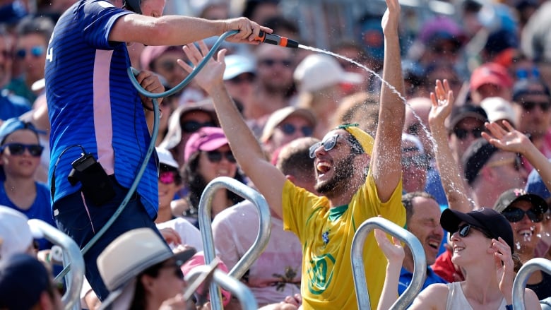 A person sprays water on people sitting in an audience