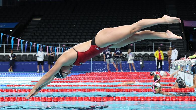 A woman dives into a pool