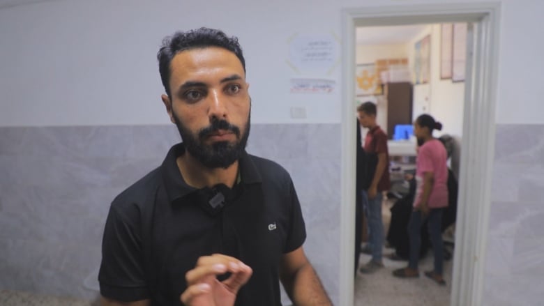 a man in a black shirt stands in a clinic