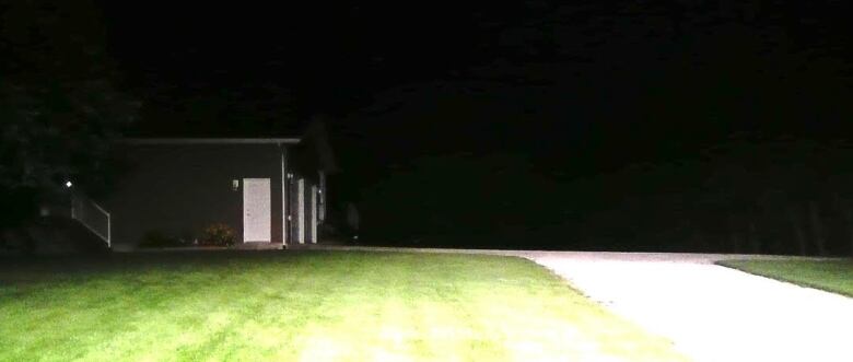 The side of a house and its garage at night.