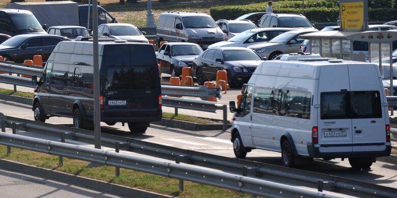 Vans ferrying Russian agents deported from the United States are seen departing Moscow's Domodedovo airport on July 9, 2010. The agents were sent home as part of a dramatic spy swap.