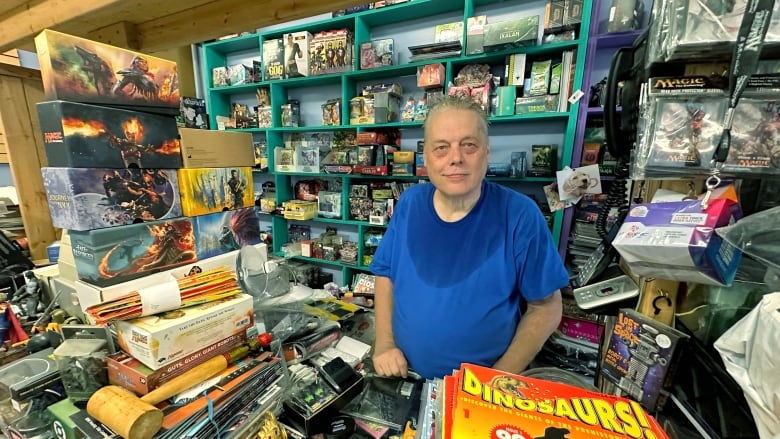 man stands in store surrounded by comic books