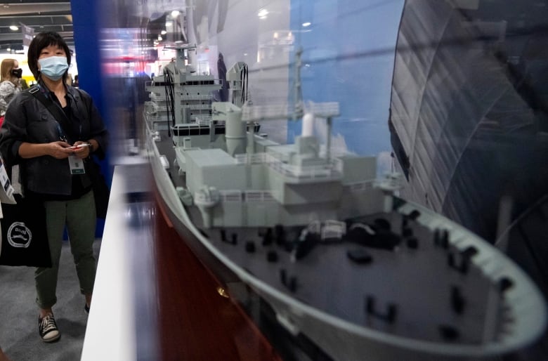 An attendee looks on at a model of a Joint Support Ship (JSS) being built at Seaspans Vancouver Shipyards, at the CANSEC trade show, billed as North Americas largest multi-service defence event, in Ottawa, on Wednesday, June 1, 2022.