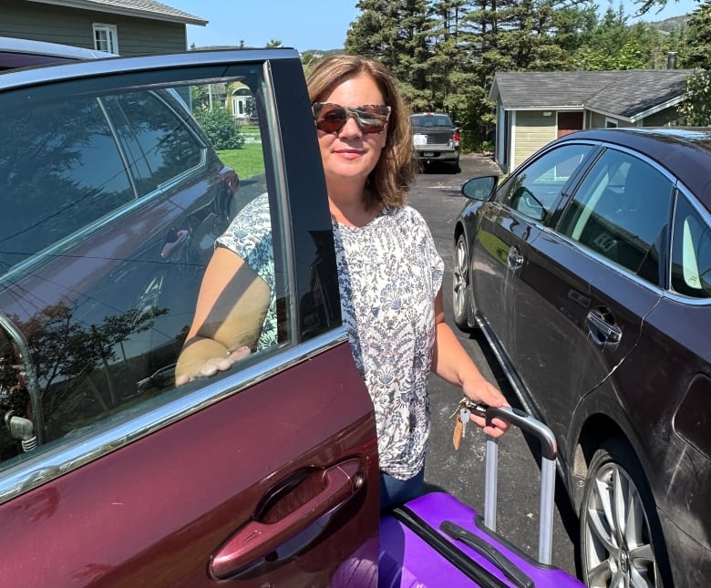 Woman getting out of vehicle with a suitcase