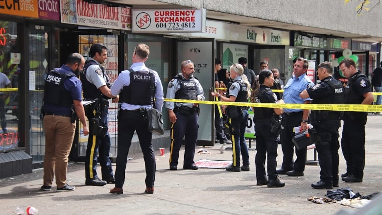 Many police officers stand outside a currency exchange