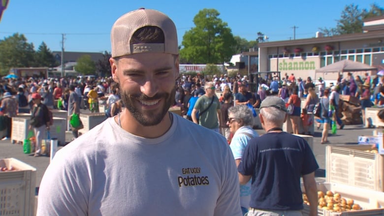 A man in white shirt with a bunch of people in the background. 