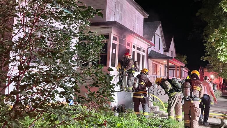 Firefighters going into a building on fire.