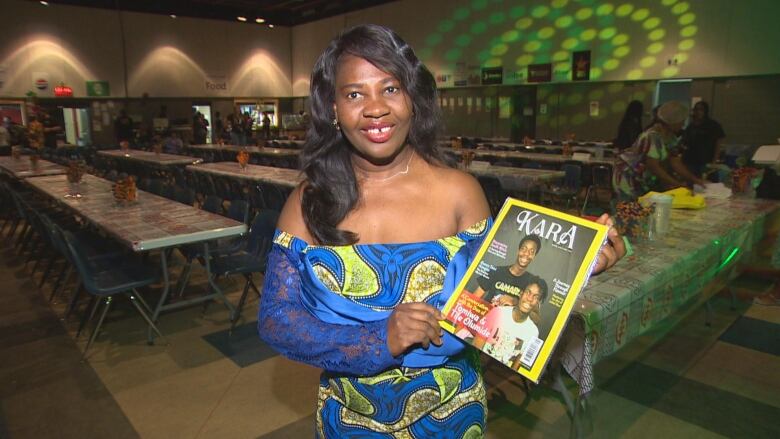 A woman stands with a magazine 