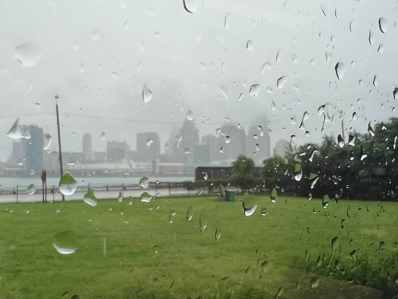 The Detroit skyline behind rain-covered glass