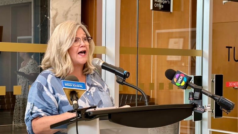 woman stands at podium