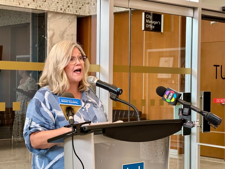 woman stands at podium