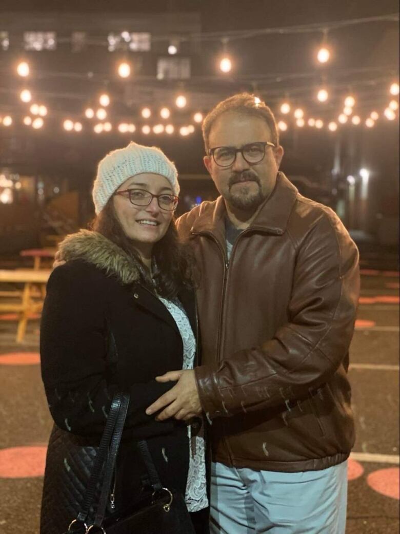 a couple standing outside posing for a photo