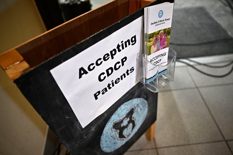 A signboard advertising that a dental office is accepting patients as part of the Canadian Dental Care Plan is seen outside the clinic in Ottawa, on Wednesday, Aug. 7, 2024.