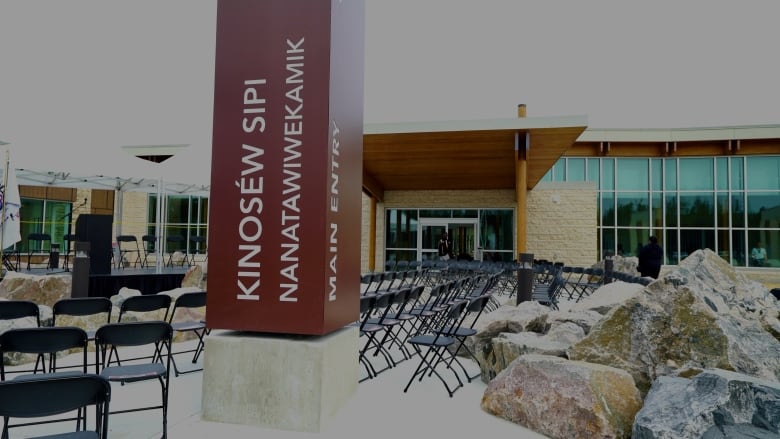 Chairs are set up in rows before a ceremony outside begins in front of a health care building. 