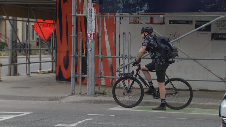 A cyclist waits at a red light.