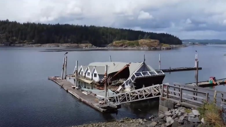 A barge sinking in the water off of a harbour