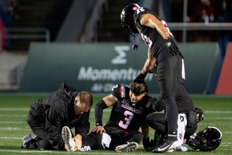 Ottawa Redblacks wide receiver Jaelon Acklin (23) taps quarterback Dru Brown (3) on the head after Brown was injured during first half CFL action against the Saskatchewan Roughriders in Ottawa, on Thursday, Aug. 8, 2024. 