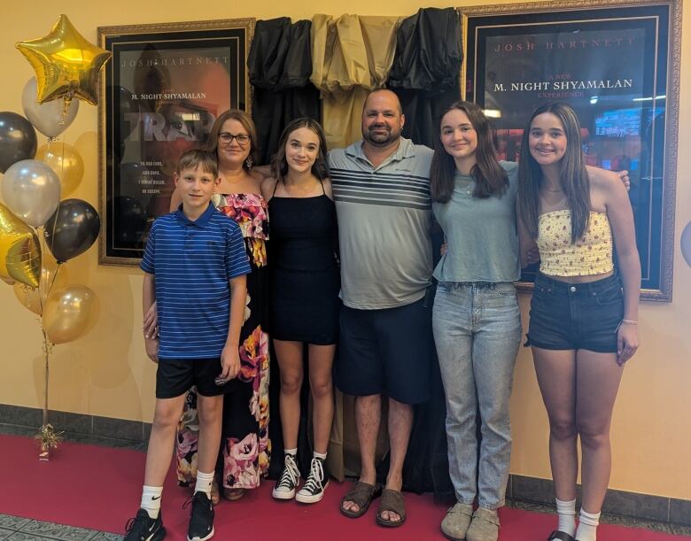 Juliet stands with a black dress in the middle of a group of family and friends for the NB premiere of Trap, her first feature film appearance.