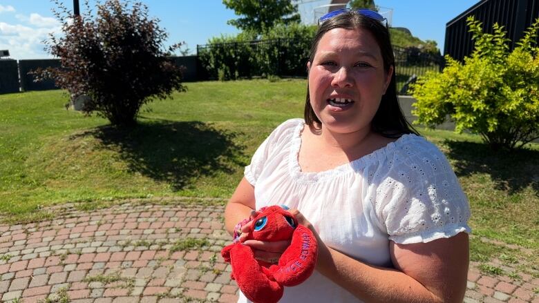 A woman holding a plush lobster.