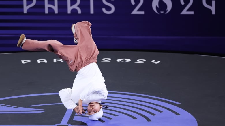 A break dancer spins on her head.