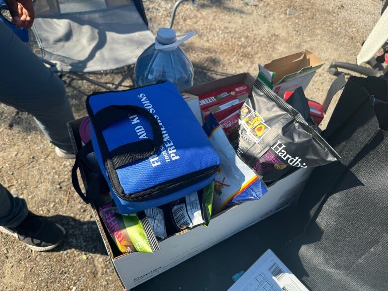 Box of chips and crackers with first aid kit on top