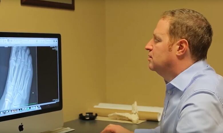 Dr. Howard Green looking at an X-ray of a foot.