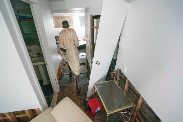 man walking in his apartment that was damaged by a flood