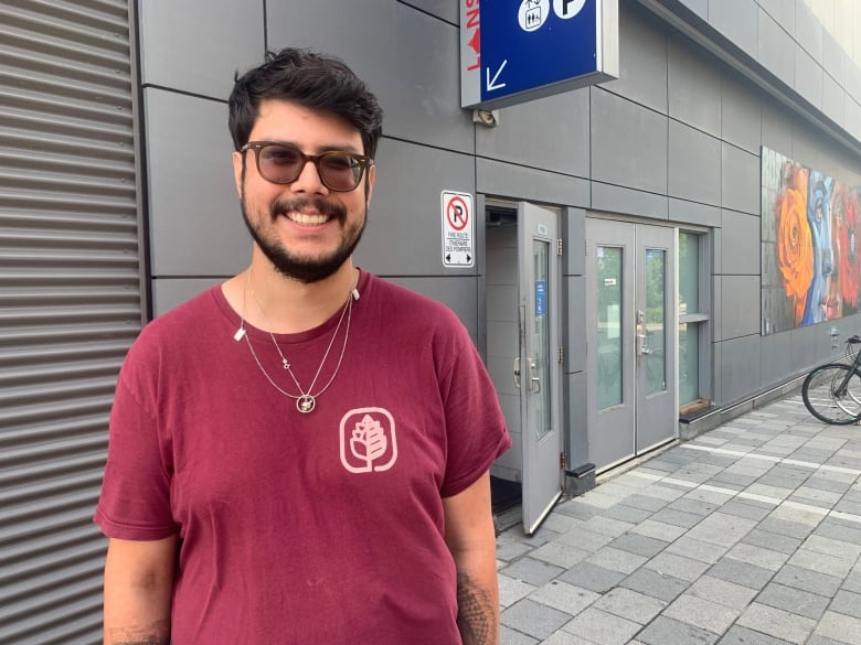 A man in a red shirt smiles.