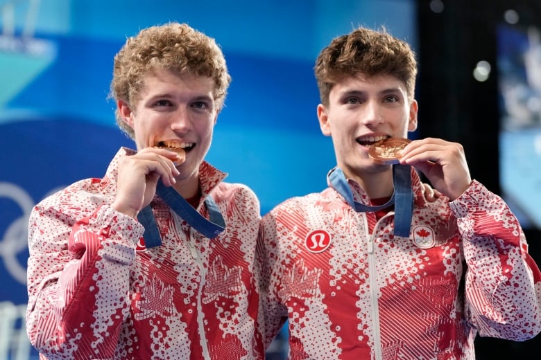 Canada's Rylan Wiens,left, and Nathan Zsombor-Murray, right, celebrate on the podium after winning the bronze medal in the men's synchronised 10m platform diving final at the 2024 Summer Olympics, Monday, July 29, 2024, in Saint-Denis, France. 