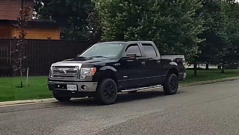 A black pickup truck parked on the side of the road.