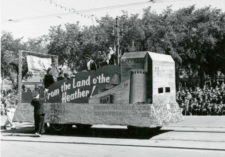 A black and white photo of a parade float with the image of a castle 