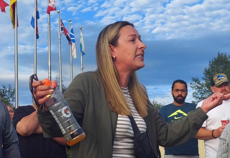 Woman with blond hair holding Gatorade bottle.