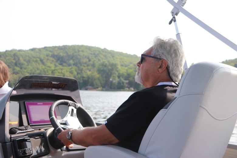 A man pilots a boat.